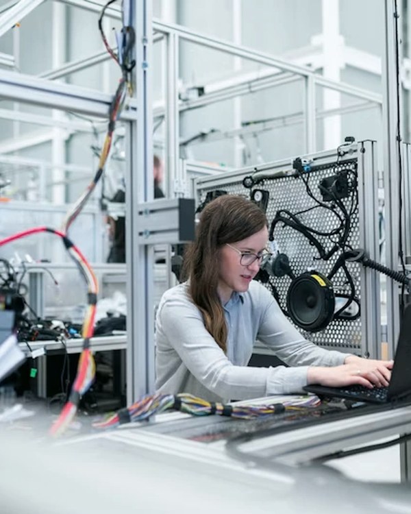 Especialista de calidad inspeccionando un dispositivo bajo la lámpara